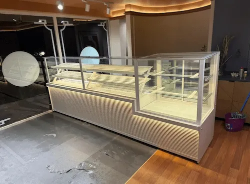Beyaz yatay oluklu panelli, LED aydınlatmalı baza, pasta ve unlu mamuller için bölümlendirilmiş modern kombine teşhir dolabı